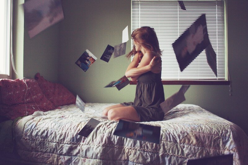 woman on bed with floating photos
