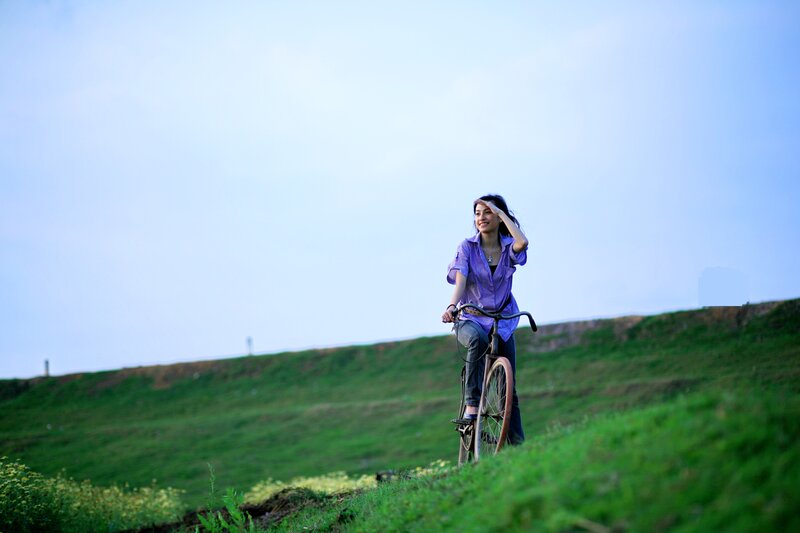 Woman on bicycle in a field