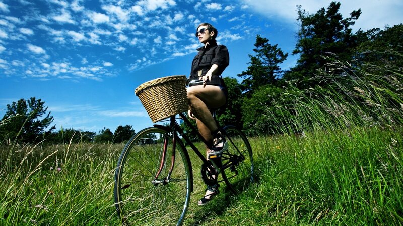 Woman on bicycle in field