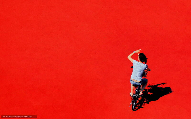 Woman on bicycle on red surface