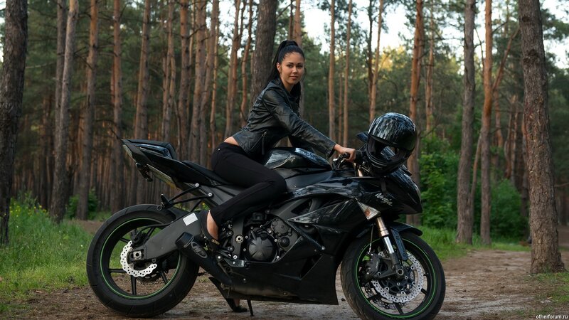 woman on black motorcycle in forest