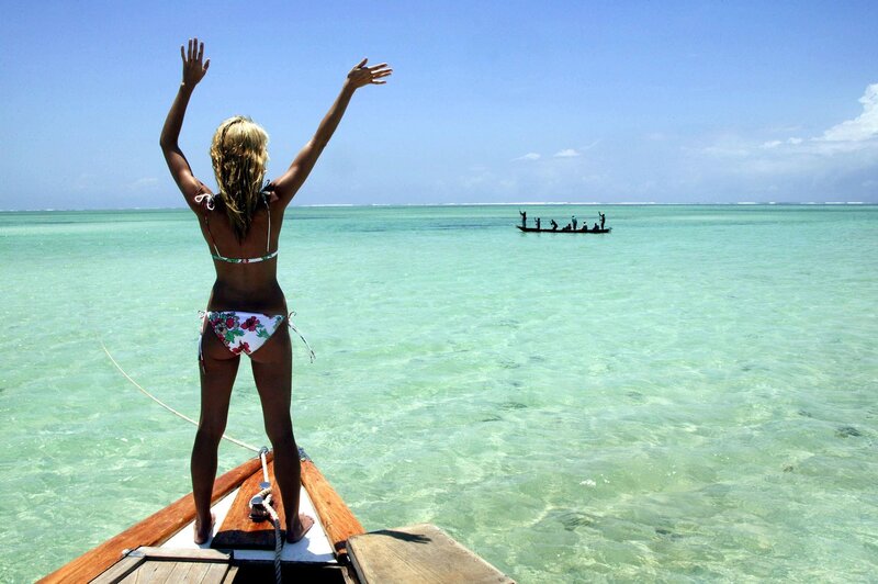 Woman on boat with arms raised