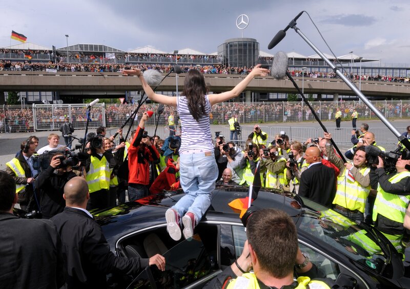 Woman on car roof at race track