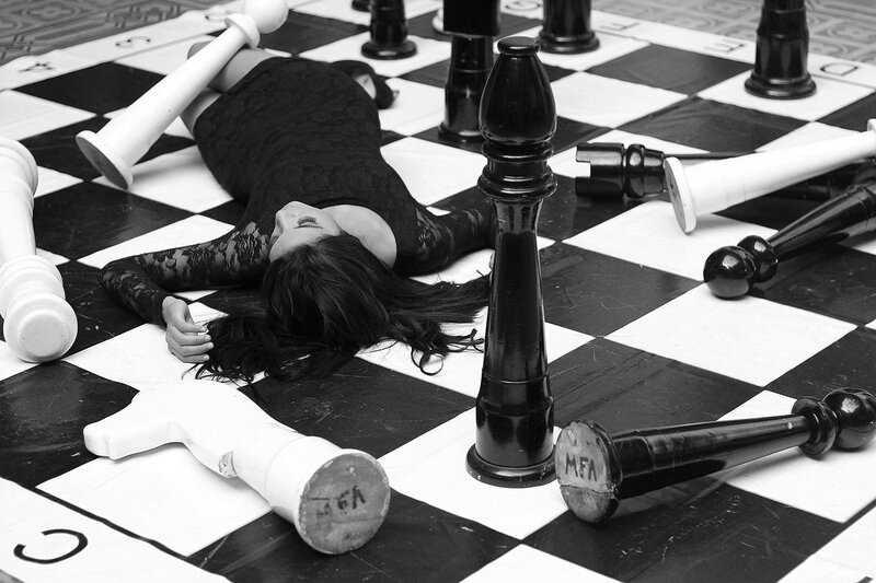Woman on Chessboard — Black, Dramatic, Photograph