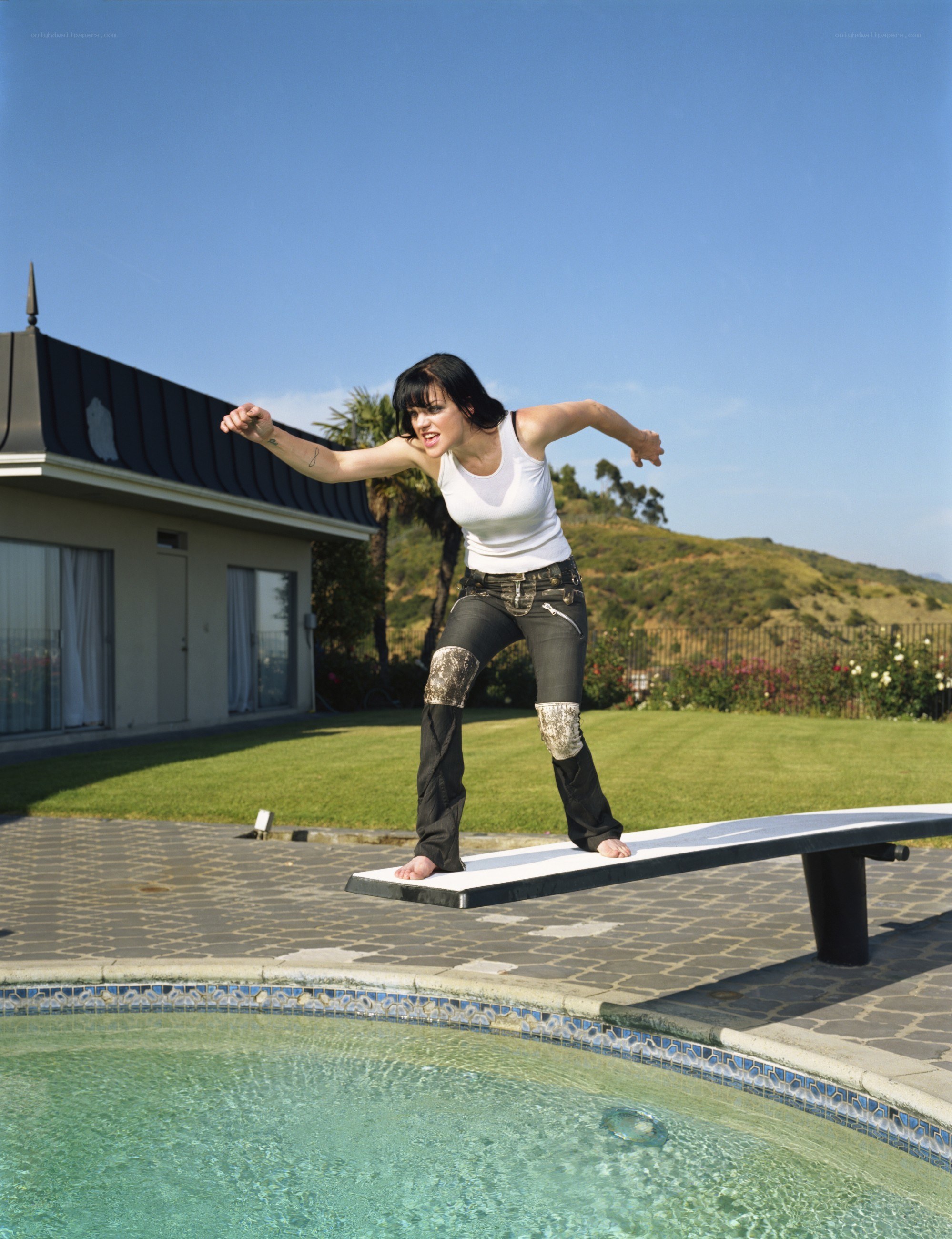 Woman on diving board by pool
