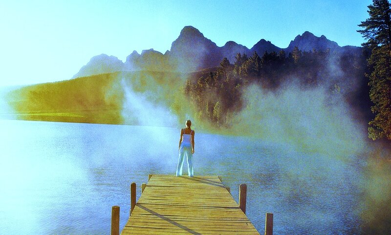 Woman on dock at misty lake