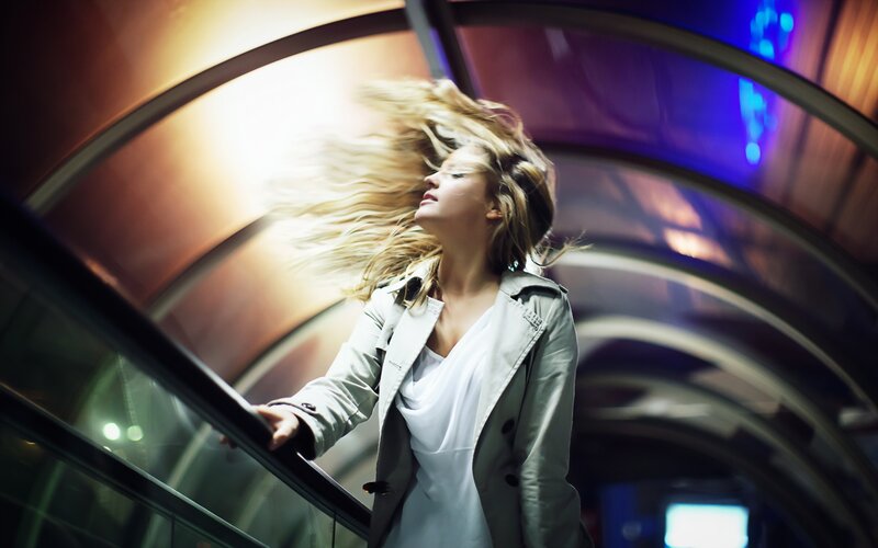 woman on escalator with wind-blown hair