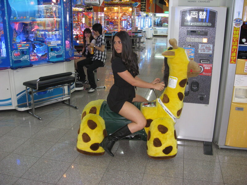 Woman on giraffe ride in arcade
