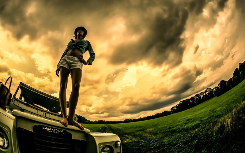 Woman on Land Rover at sunset