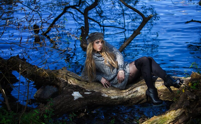 Woman on log by lake