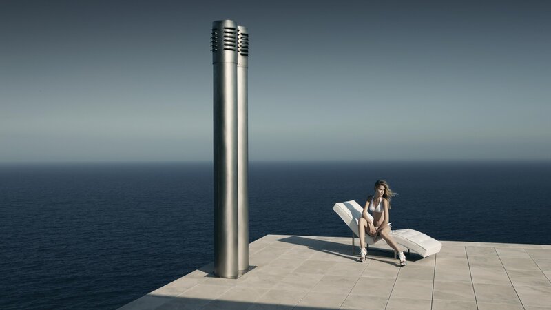 Woman on lounge chair by ocean