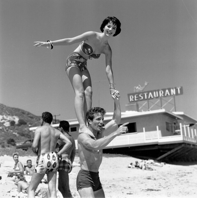 Woman on man's shoulders at beach
