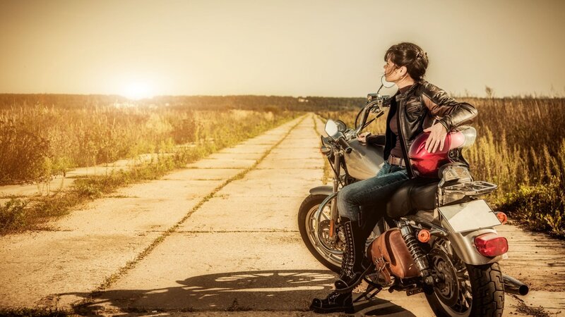 Woman on motorcycle at sunset