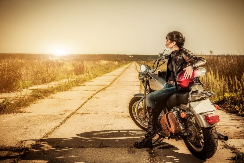 Woman on motorcycle at sunset