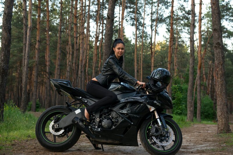 Woman on motorcycle in forest