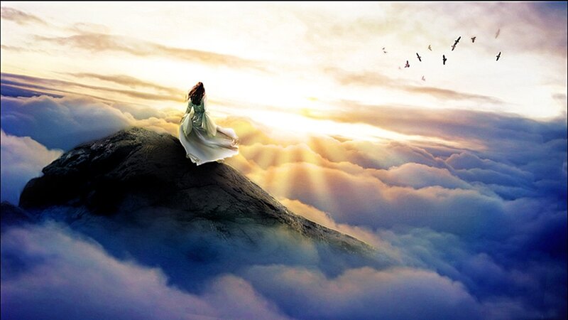 woman on mountain above clouds