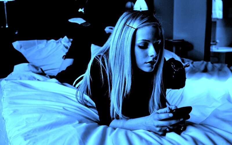 woman on phone in bed