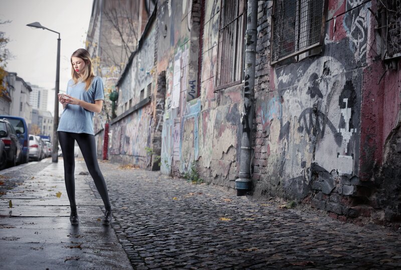 woman on phone in graffiti alley