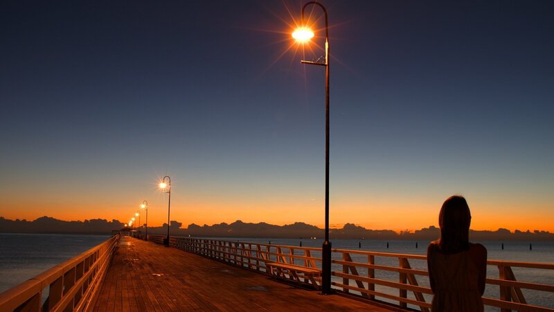 woman on pier at sunset