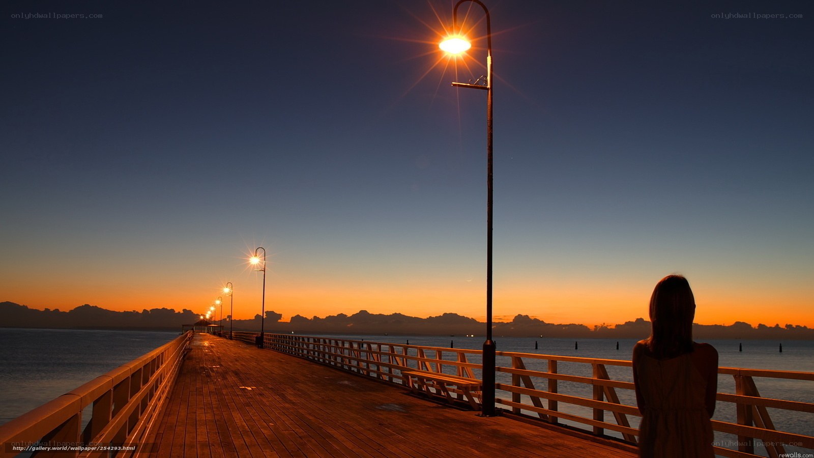 woman on pier at sunset