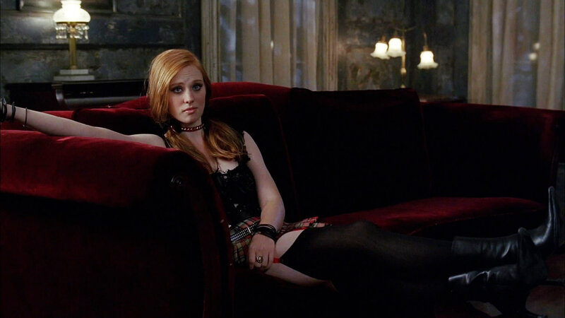 Woman on red couch in dark room