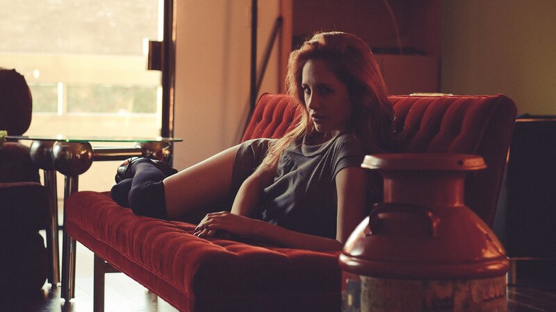 woman on red couch in warm light