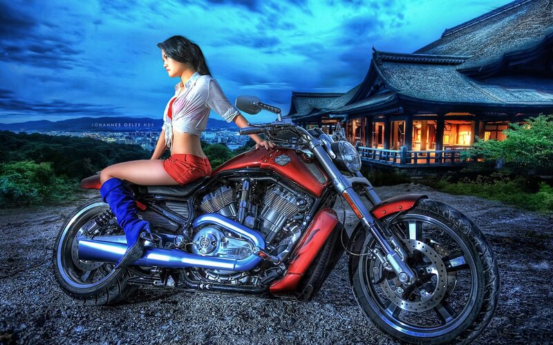 Woman on red motorcycle at dusk