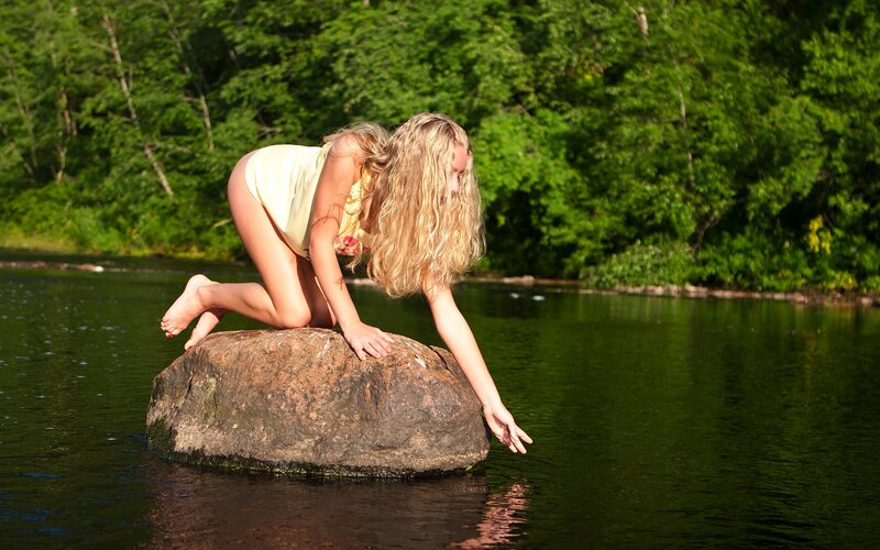 woman on rock by river