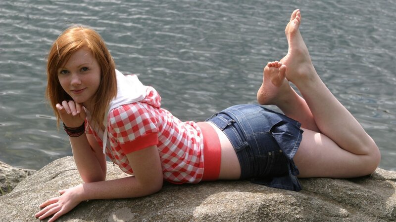 Woman on rock by water