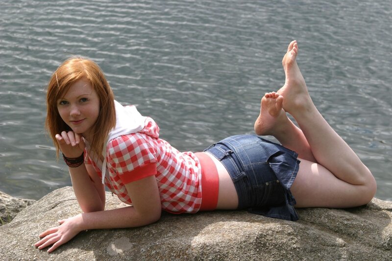 Woman on rock by water