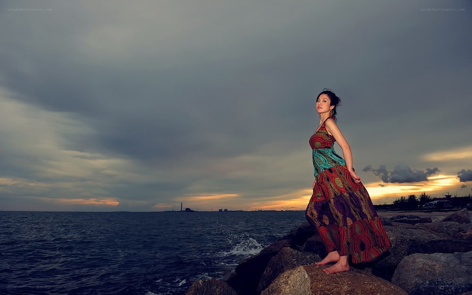 Woman on rocks at sunset