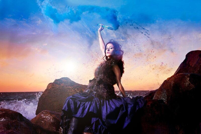 woman on rocks with smoke bomb