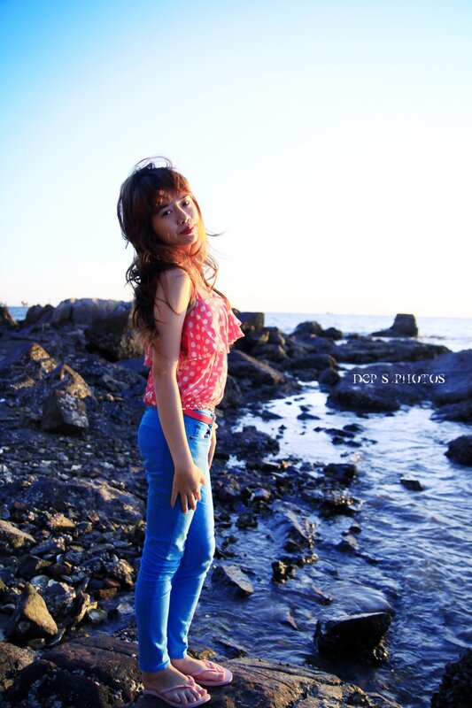 woman on rocky beach at sunset