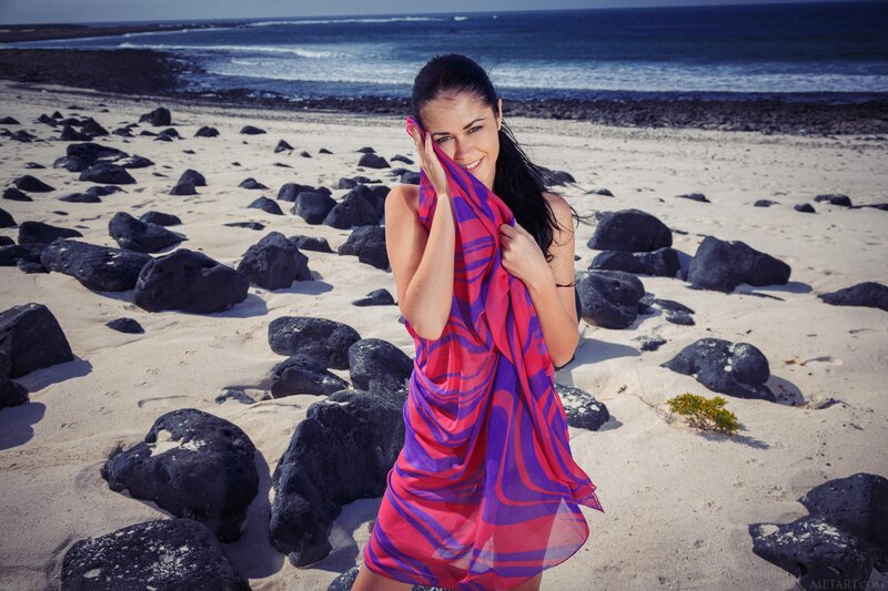 Woman on rocky beach with scarf
