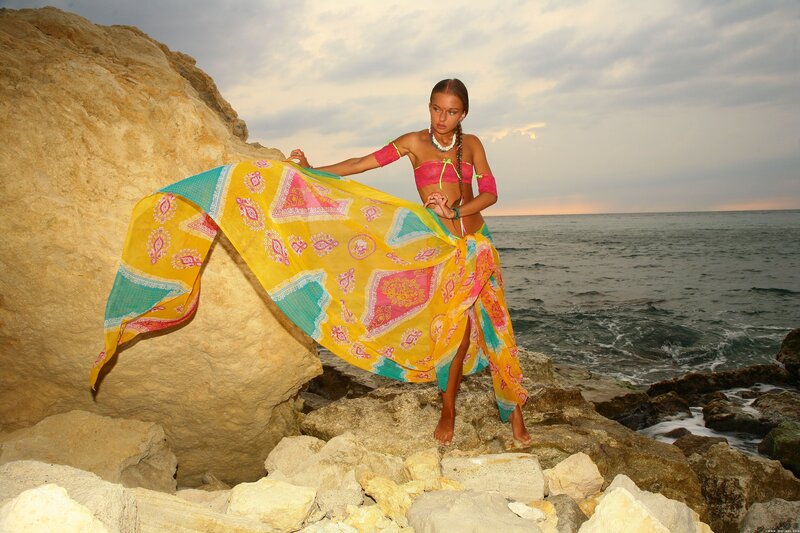 Woman on rocky beach with scarf