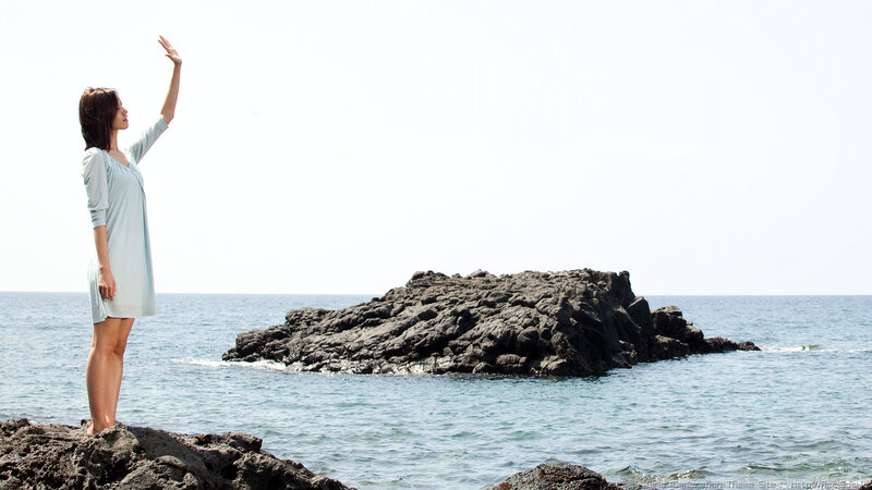 Woman on rocky shore