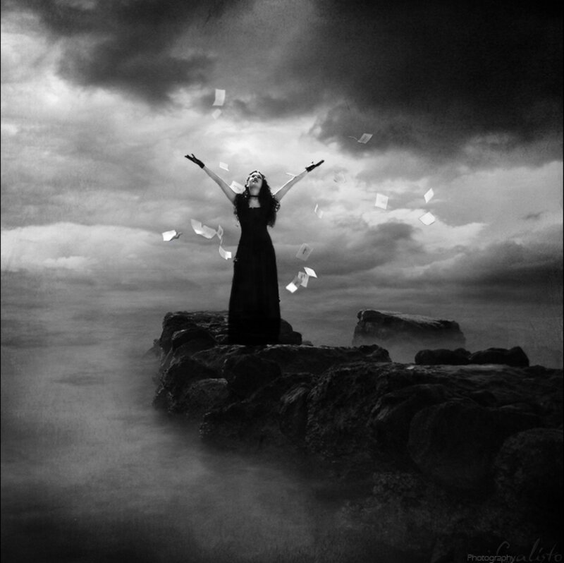 Woman on Rocky Shore — Black, Dramatic, Photograph, Clouds