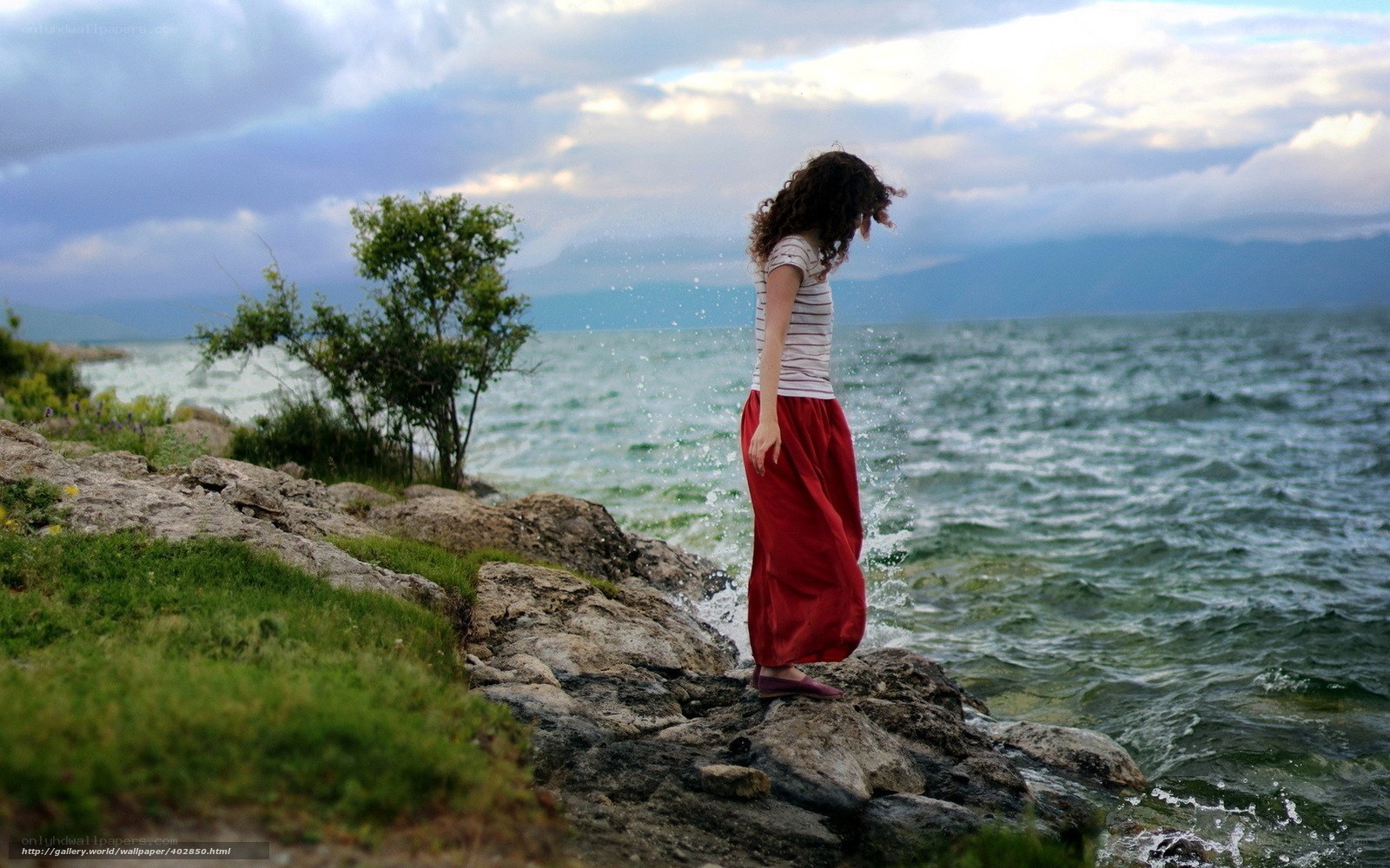 Woman on rocky shore by the sea
