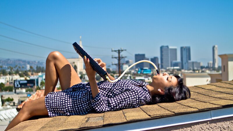 Woman on rooftop with electronic device