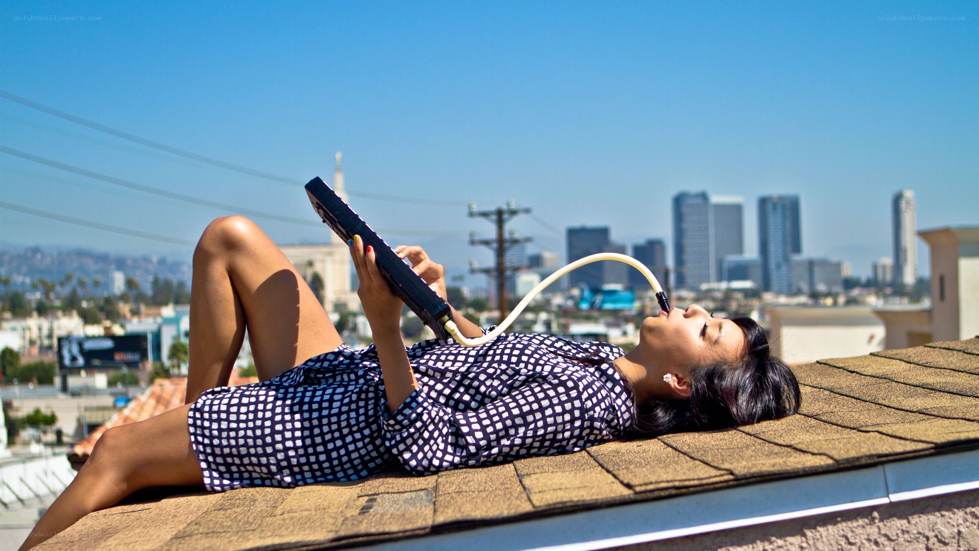 Woman on rooftop with electronic device