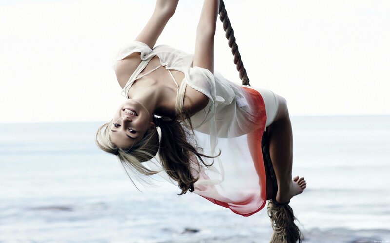woman on rope swing at beach