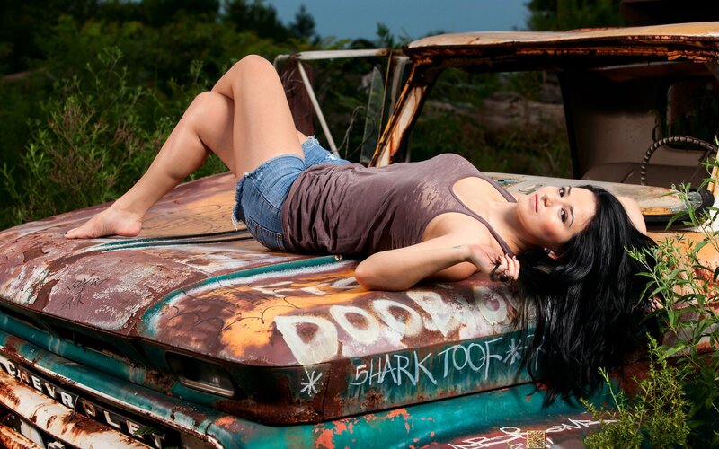 woman on rusty car hood