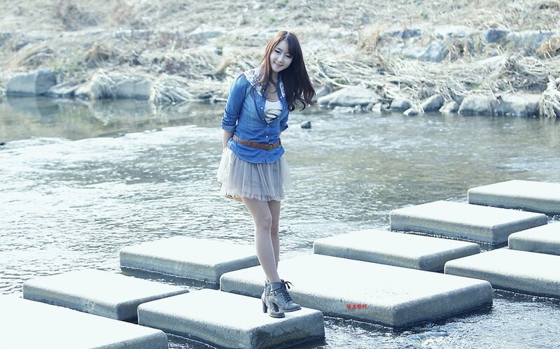 Woman on stepping stones by a river