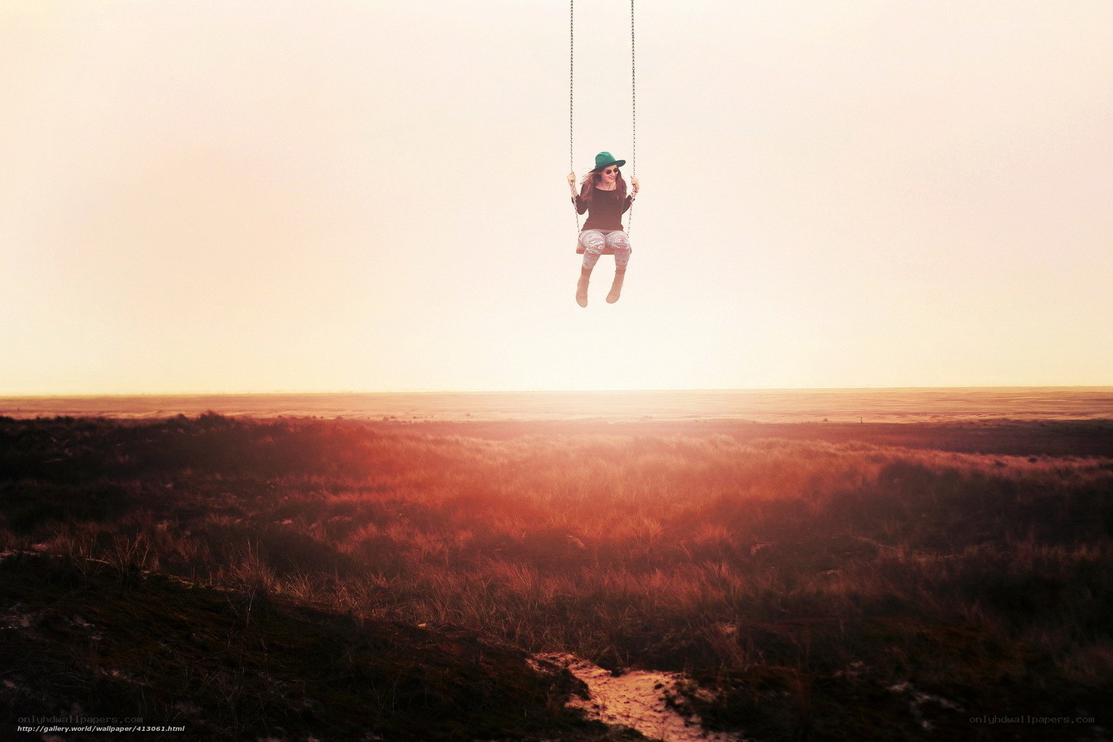 Woman on swing at sunset