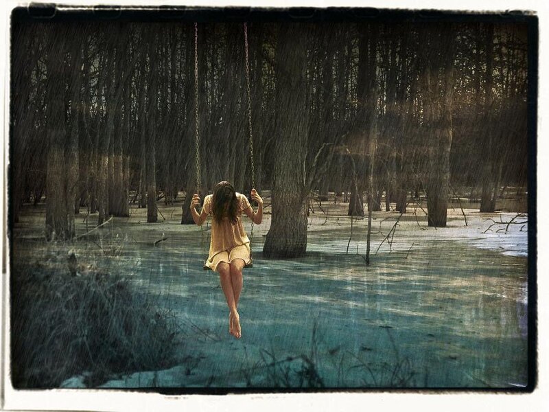 Woman on swing in flooded forest