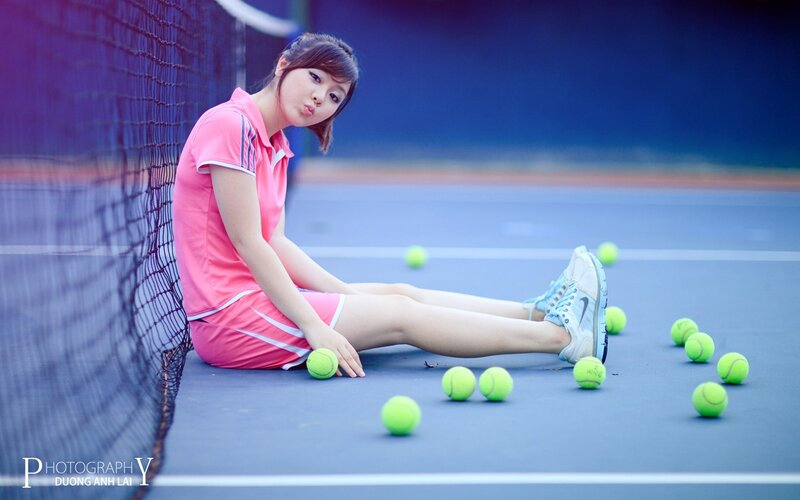 woman on tennis court with balls