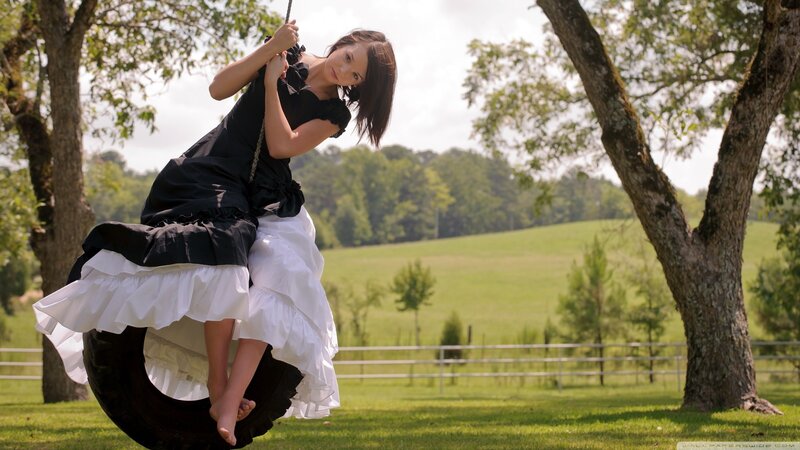 Woman on tire swing in field