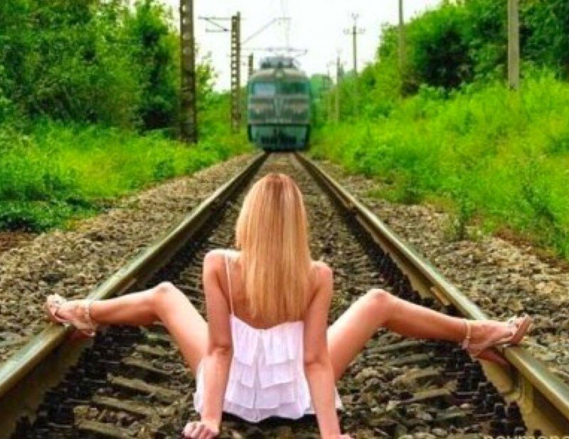 Woman on train tracks with approaching train