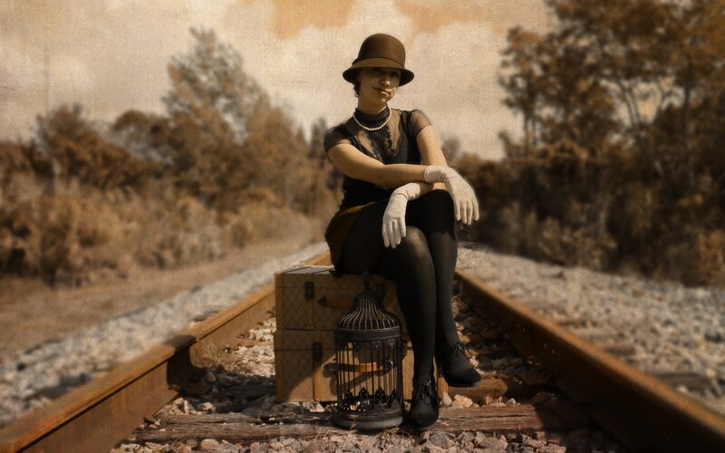 Woman on train tracks with birdcage