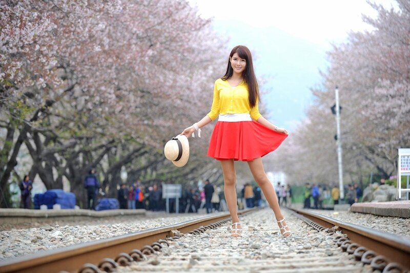 Woman on train tracks with cherry blossoms